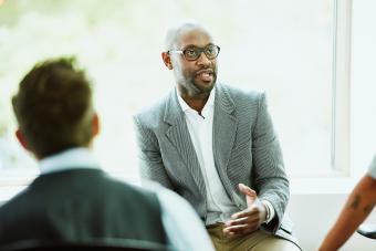 Businessman leading team during informal team meeting in office