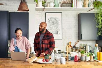 Couple preparing food and laughing in kitchen