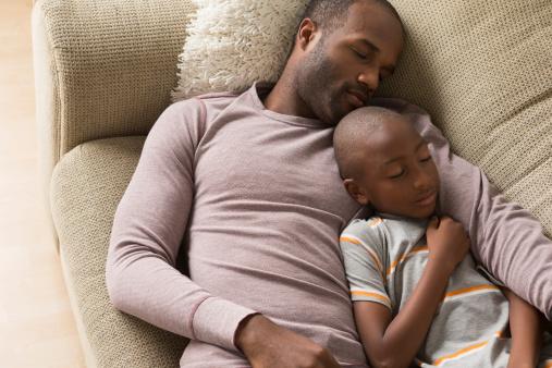 Father and son sleeping on sofa