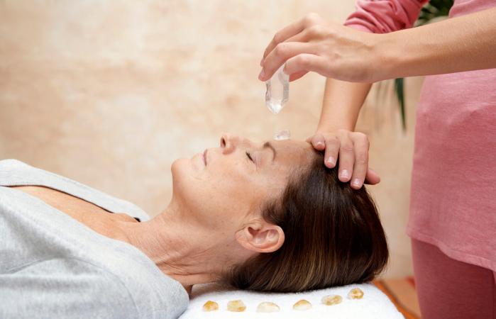 Woman receiving crystal healing treatment