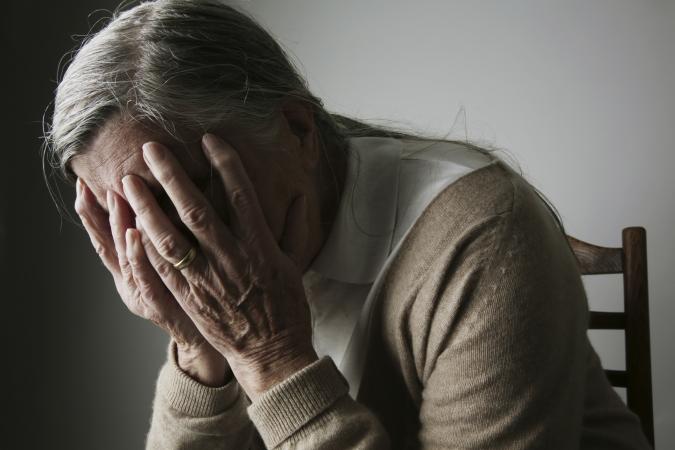 Sad woman holding head in hands