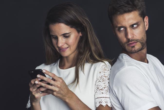 Jealous man watches partner texting