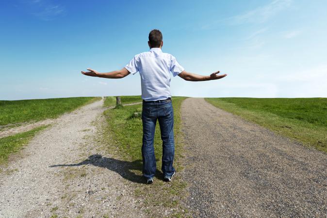 man standing at a fork in the road