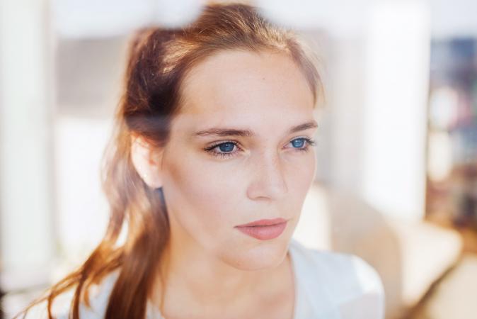 Woman looking serious behind a window