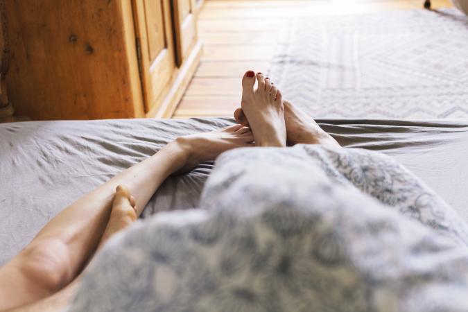 Young couple's feet while lying in bed