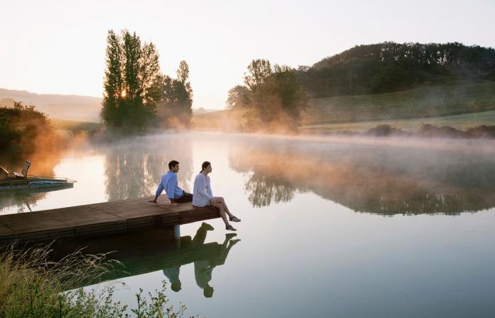 Couple relaxing on dock of lake
