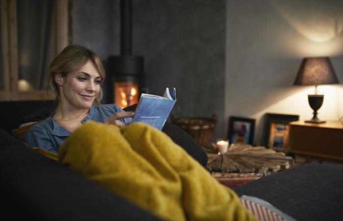 woman reading a book on couch