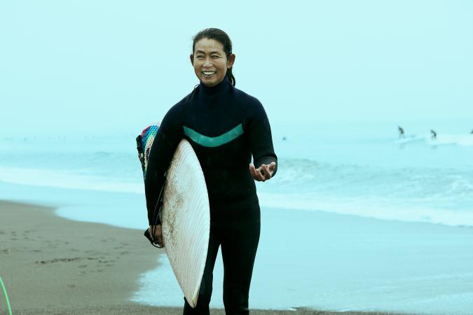 Woman on beach with surfboard