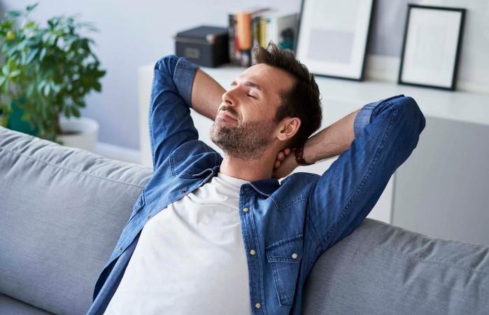man sitting on sofa daydreaming