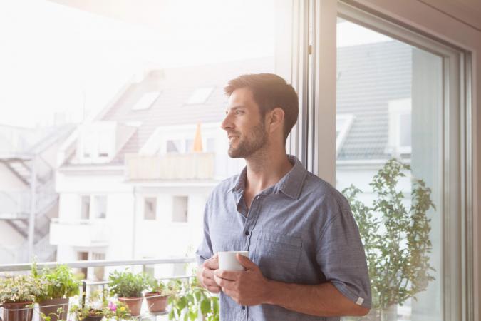 Smiling man looking out of window