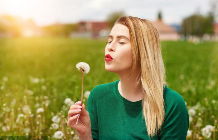 woman blowing daffodil