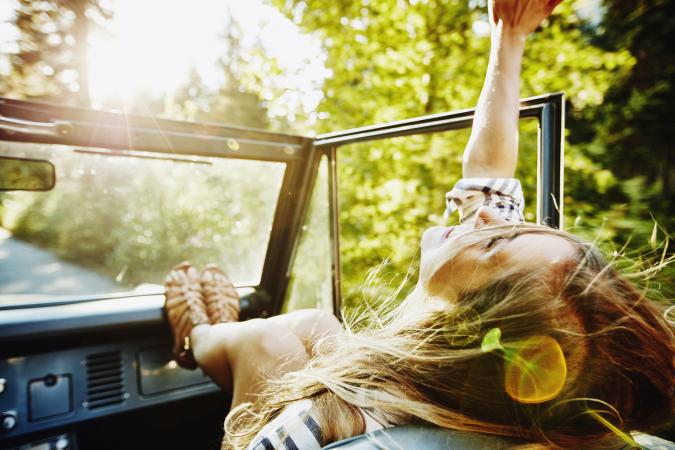 Woman riding in passenger seat of convertible