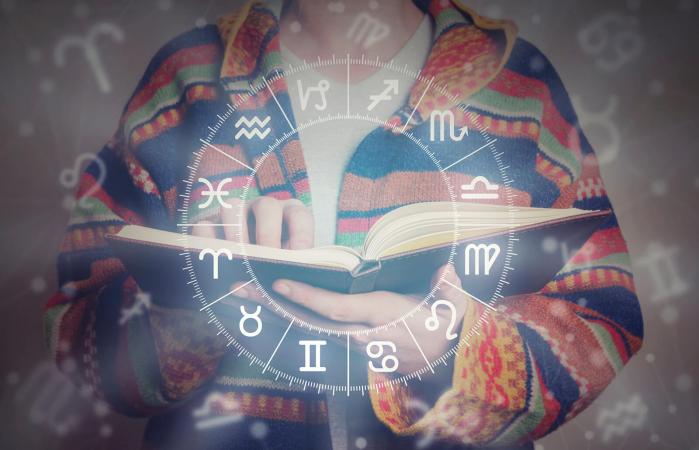 person with book and horoscope wheel