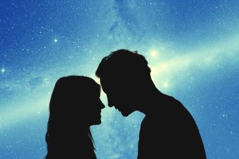 Siluetas de una pareja de jóvenes bajo el cielo estrellado