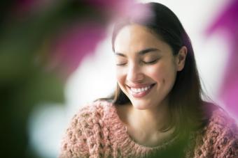 Mujer coqueta detras de flores rosas