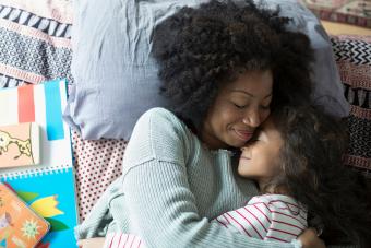 Madre e hija abrazándose en la cama