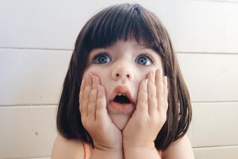 niño libra sosteniendo su cara