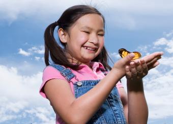 niña sosteniendo una mariposa