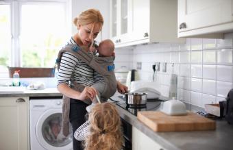 Mujer cocinando en la cocina con su bebé