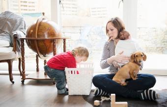 Niño jugando en casa con su madre y su hermanita