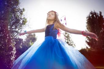 Chica bailando y soñando despierta con un vestido azul