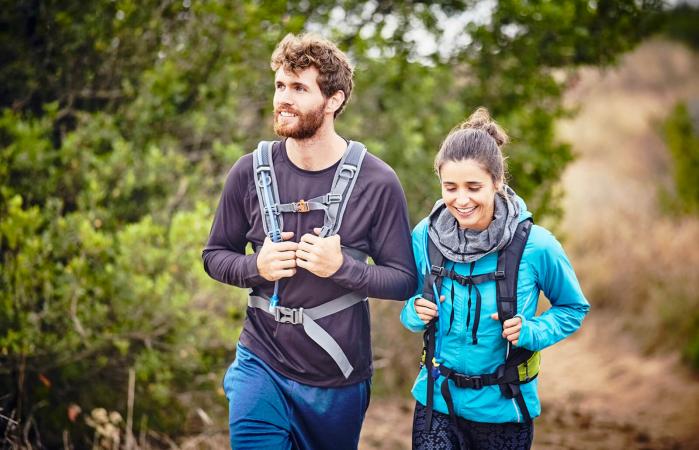Sonriente pareja haciendo excursionismo