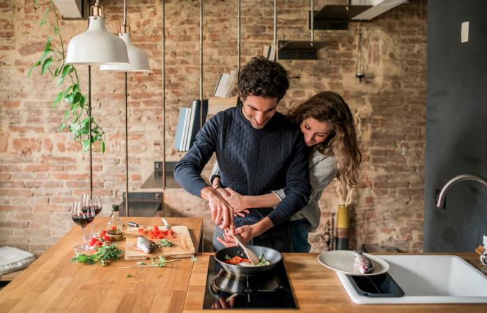 Pareja joven cocinando en casa
