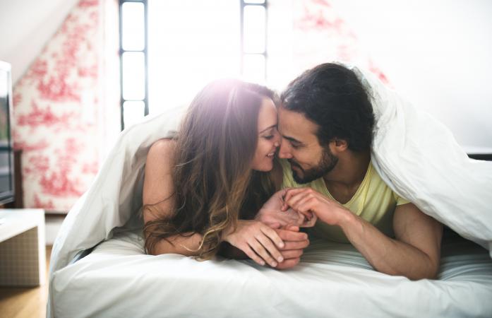 Cariñosa pareja acurrucada en la cama