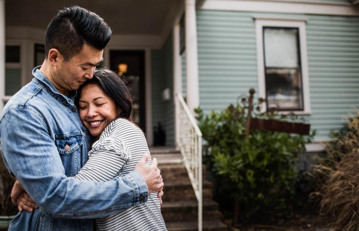 Joven pareja frente a su casa