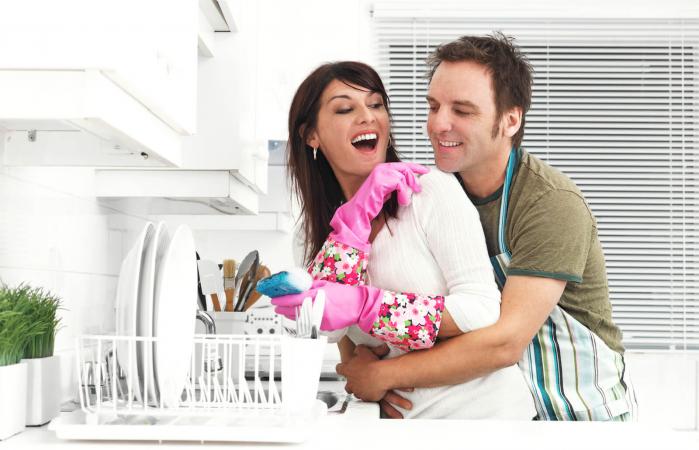 Una pareja en la cocina, lavando platos