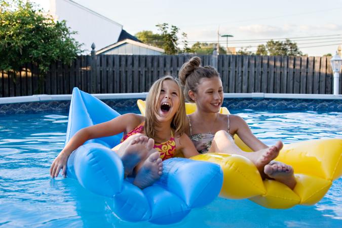 Kids on inflatables in swimming pool