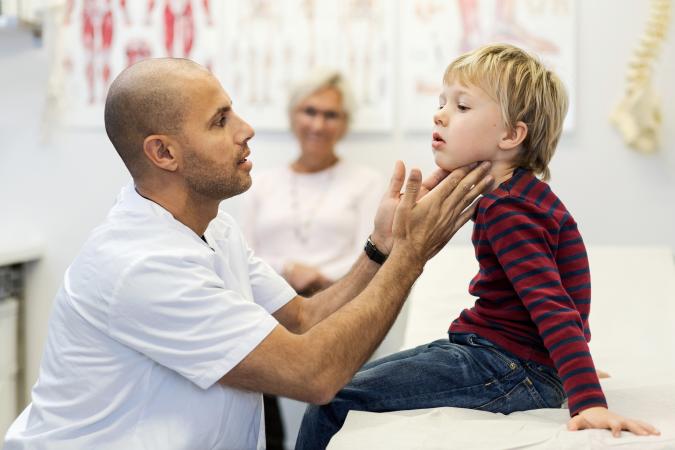 doctor checking boys throat