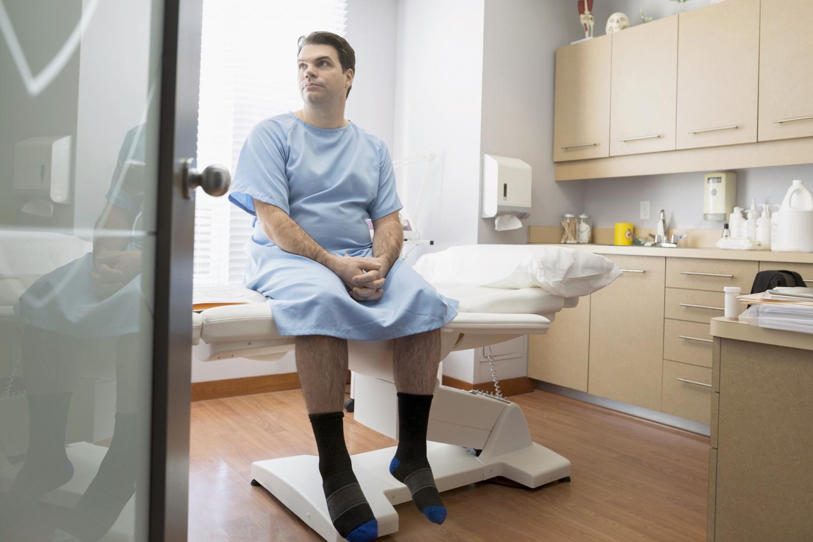 Patient in hospital gown waiting in examination room