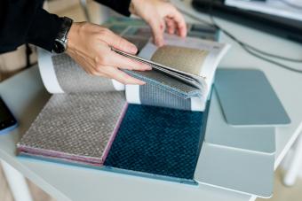 Woman choosing fabrics swatches for sofa in store