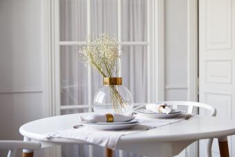 Small, round table with glass vase of gypsophila