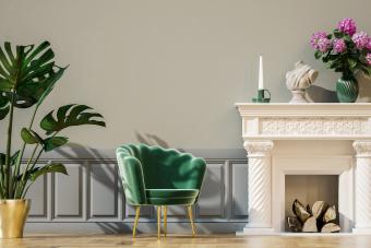 Living room with single chair, potted plant, wall panels and fireplace 