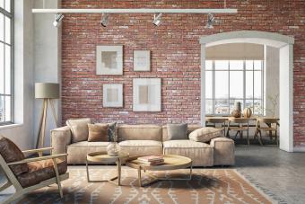 Bohemian living room interior with beige colored furniture and wooden elements and brick wall