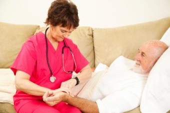 Nurse taking patient's pulse while consulting her watch.