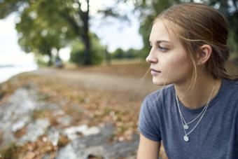 Young woman at the riverside contemplating