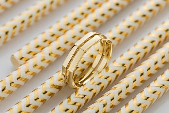 Geometric shape gold ring on golden glossy background 