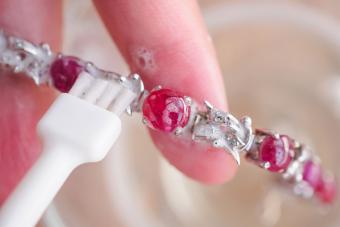 cleaning ruby bracelet with soapy solution and brush