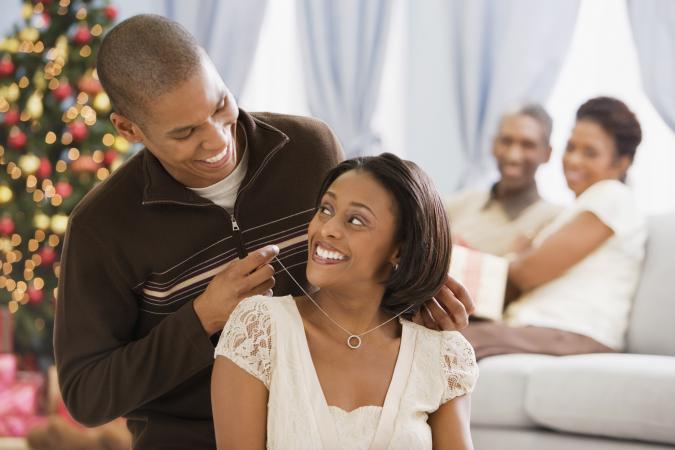 Mother receiving gemstone necklace from husband