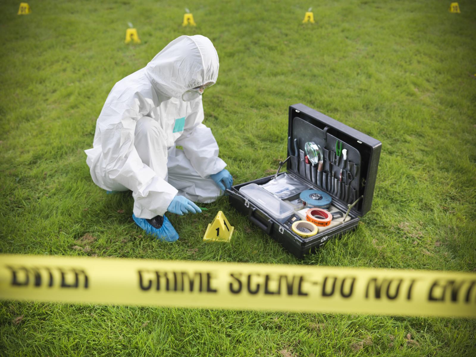 Forensic scientist inspecting toolkit at crime scene