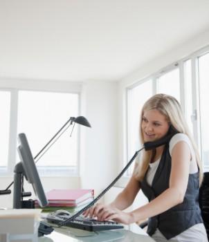 Woman multitasking on phone and computer