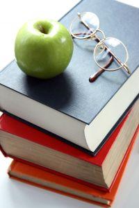 Ready glasses, an apple, and books to study