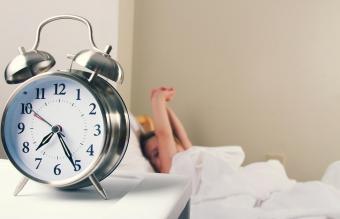 child waking up with an alarm clock