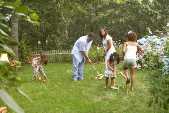 Couple playing croquet with their three daughters