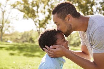 father kissing son's forehead showing support