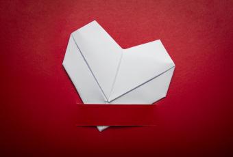 origami folded heart on red background