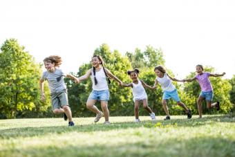 Children holding hands and running in a park